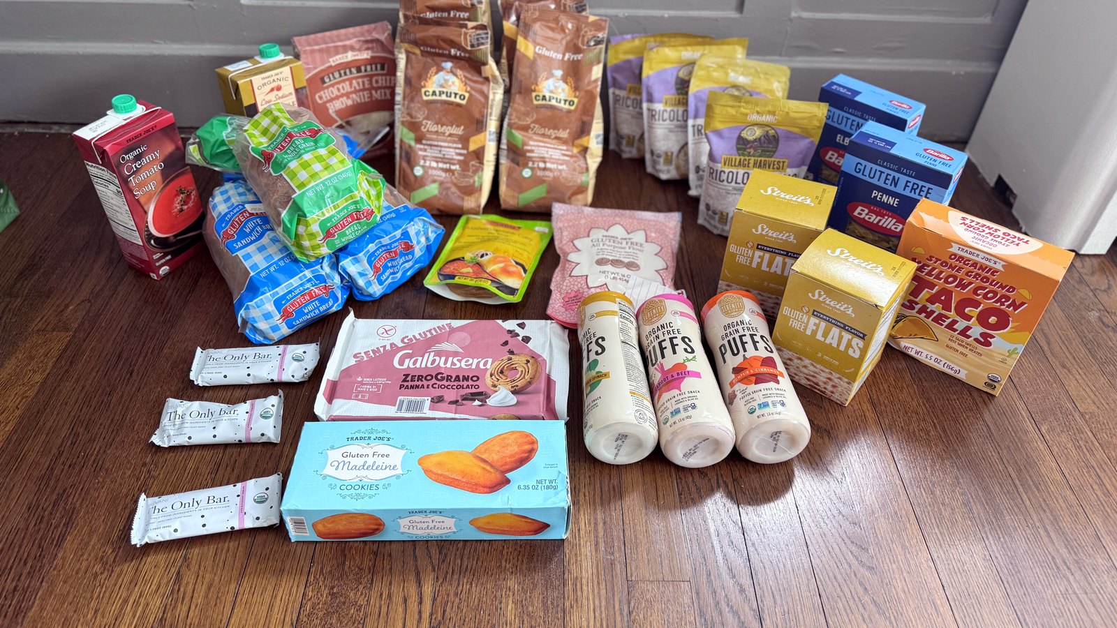 Gluten-free groceries laid out on a wood floor after a community food drive